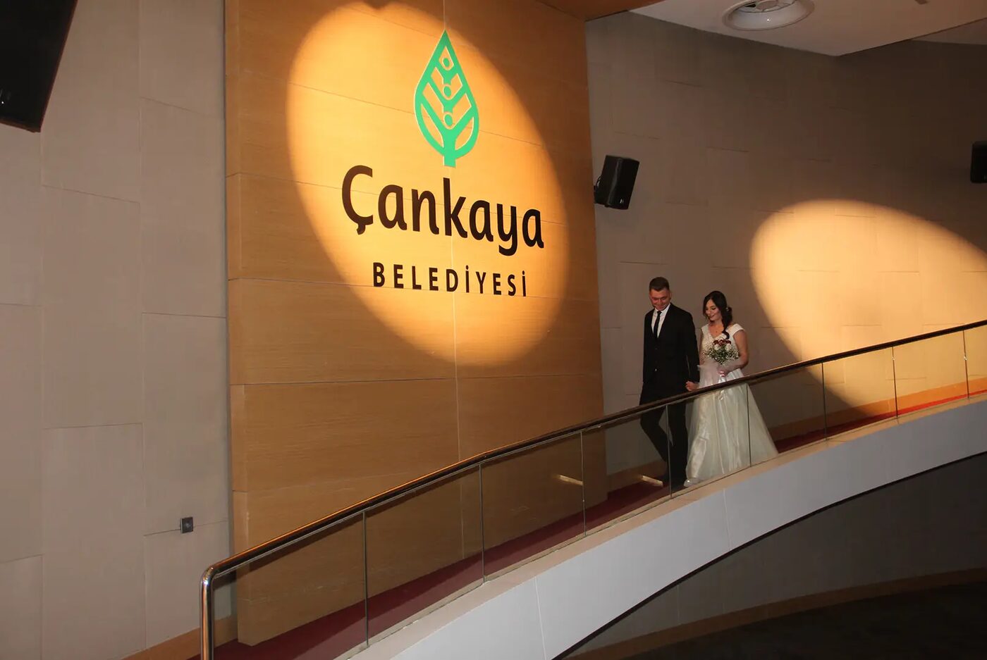 Gelin damat Çankaya Belediyesi logosu önünde yürürken